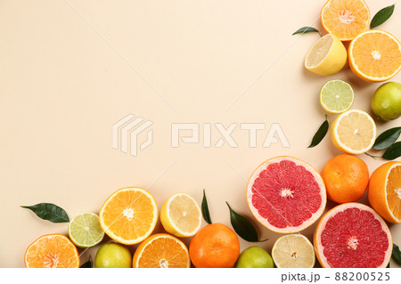 Flat lay composition with tangerines and different citrus fruits on beige background. Space for text 88200525
