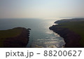 Atlantic Ocean cliffs with sun glare in drone flight over Stradbally Cove, Cooper Coast, Waterford, Ireland. 88200627