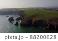 panning over large Atlantic Ocean cliffs with crashing waves in drone flight over Stradbally Cove, Cooper Coast, Waterford, Ireland. 88200628