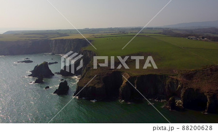 panning over large Atlantic Ocean cliffs with crashing waves in drone flight over Stradbally Cove, Cooper Coast, Waterford, Ireland. panning over large Atlantic Ocean cliffs with crashing waves in drone flight over Stradbally Cove, Cooper Coast, Waterford, Ireland. 88200628