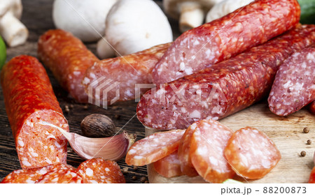 sliced pieces of sausage from meat are lying on a cutting board 88200873