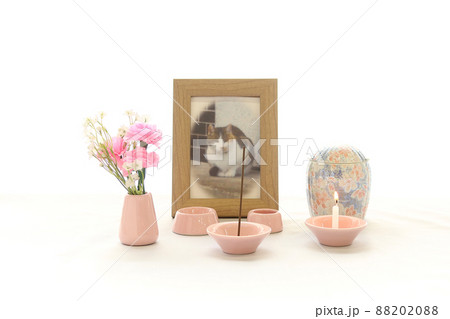 窓辺に飾られた手元供養用のペットの写真と骨壺13 88202088