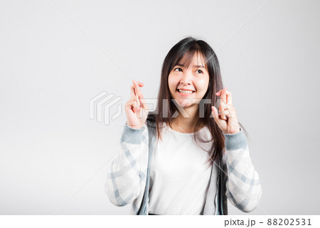 Happy woman have superstition her holding fingers crossed for good luck gesture Happy woman have superstition her holding fingers crossed for good luck gesture 88202531