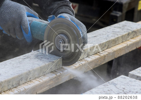 Dust while grinding close-up of worker cutting granite plate with grinder. Dust while grinding close-up of worker cutting granite plate with grinder. 88202638
