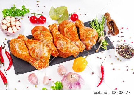 Barbecue marinated chicken dramsticks black culinary board,white background with fresh rosemary leaves and cherry tomatoes,various spices,close-up.Semi-finished product,quick cooking.Baner of meat. Barbecue marinated chicken dramsticks black culinary board,white background with fresh rosemary leaves and cherry tomatoes,various spices,close-up.Semi-finished product,quick cooking.Baner of meat. 88208223