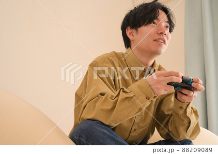 家でゲームをしている男性 88209089