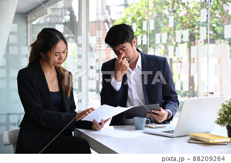 Tired businessman getting bored while listening to his boss on a meeting at the office. Tired businessman getting bored while listening to his boss on a meeting at the office. 88209264