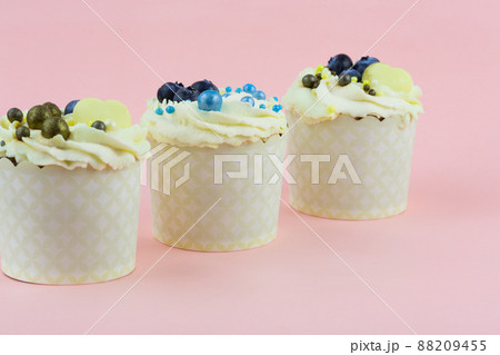 Three cupcakes on a pink background. Wedding confectionery Three cupcakes on a pink background. Wedding confectionery 88209455