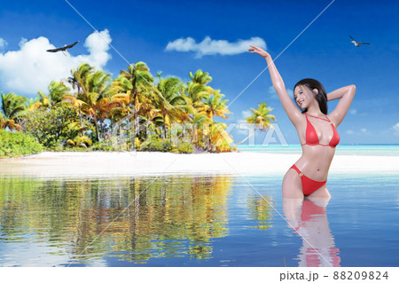 自然豊かな無人島を背景に赤いビキニを着た黒髪の女性が片手をしなやかに上げ海の中でポーズするのイラスト素材 8094