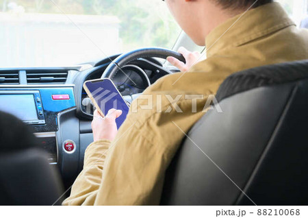 運転しながらスマホを操作している男性 88210068