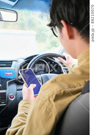 運転しながらスマホを操作している男性 88210070