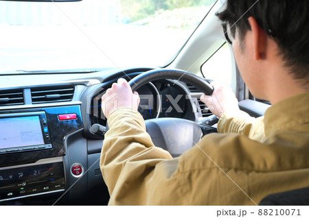 運転しながらスマホを操作している男性 運転しながらスマホを操作している男性 88210071