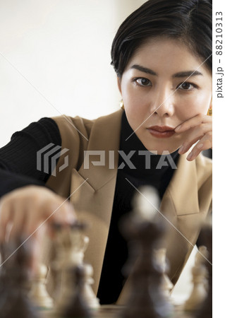 チェスの駒を動かす女性 88210313