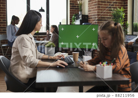 Working businesswoman using greenscreen on computer in agency office. Startup employee looking at monitor with blank mockup background, isolated template and chroma key copy space on display. Working businesswoman using greenscreen on computer in agency office. Startup employee looking at monitor with blank mockup background, isolated template and chroma key copy space on display. 88211956