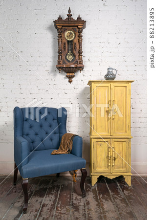 Vintage blue armchair, yellow cupboard, pendulum clock and orange scarf 88213895