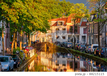 Delt canal with old houses and cars parked along on sunset Delt canal with old houses and cars parked along on sunset 88215115