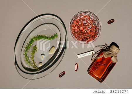 Glass bottle with algae oil, jelatin capsules and seaweed on brown paper Glass bottle with algae oil, jelatin capsules and seaweed on brown paper 88215274
