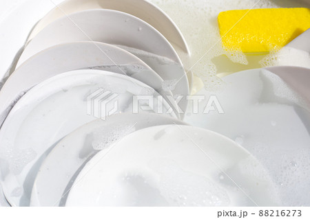 Dish washing, Dirty dishes soaking in kitchen sink. 88216273