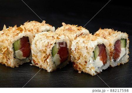 Traditional delicious fresh sushi roll set on a black background. Sushi roll with rice, cream cheese, avocado, salmon, sesame. Philadelphia. Sushi menu. Japanese kitchen, restaurant. Traditional delicious fresh sushi roll set on a black background. Sushi roll with rice, cream cheese, avocado, salmon, sesame. Philadelphia. Sushi menu. Japanese kitchen, restaurant. 88217598