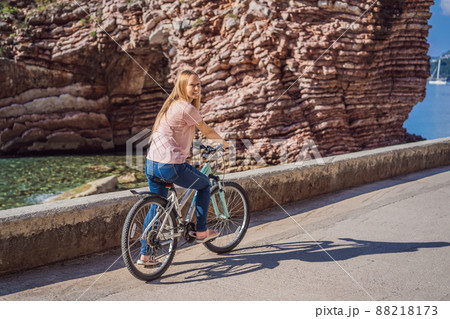 Woman tourist on a bicycle explores Budva in Montenegro. Cycling in Montenegro concept 88218173