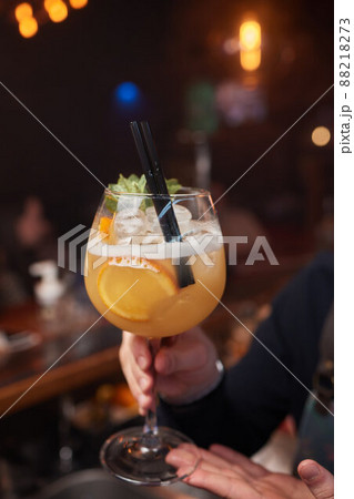 magnificent view of the crushed ice that is poured from the scoop into glass with cocktail on the bar. 88218273
