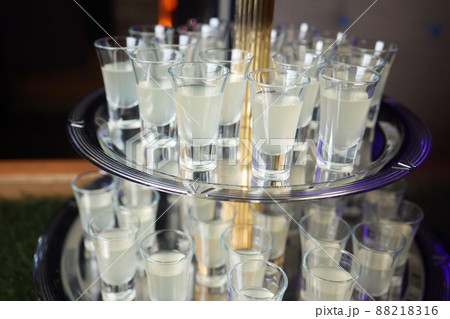 Barman pouring hard spirit into glasses in detail. 88218316