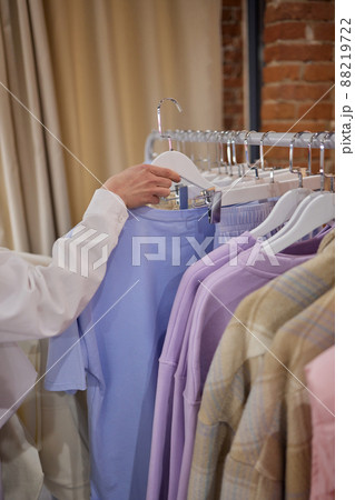 Woman selecting clothes in shop.Close up of hangers row. Woman selecting clothes in shop.Close up of hangers row. 88219722
