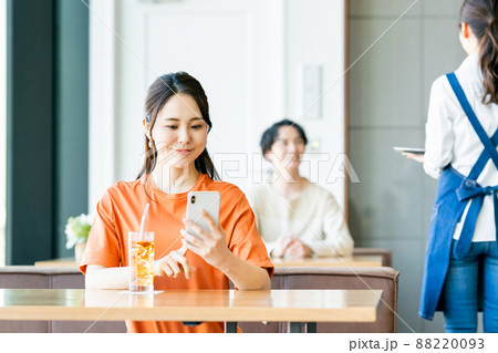カフェでスマホを見る若い女性 カフェでスマホを見る若い女性 88220093
