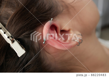 Stretched lobe piercing, grunge concept. Pierced woman ear with black plug tunnel. industrial and rook. Stretched lobe piercing, grunge concept. Pierced woman ear with black plug tunnel. industrial and rook. 88220483