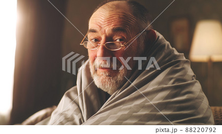 Senior man in glasses wrapped in blanket 88220792
