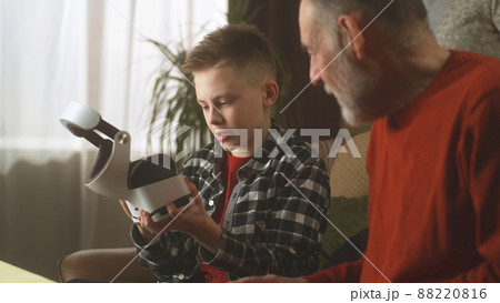 Grandchild showing virtual reality to grandfather 88220816