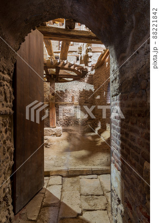 Open grunge door revealing aged water mill turning inside weathered mill building 88221842