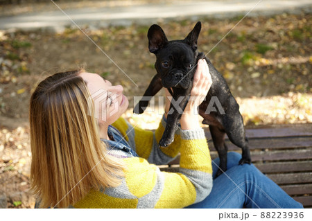 woman sitting on a bench with french bulldog 88223936