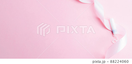 Menstrual tampon feminine hygiene. Pink ribbon with menstrual tampon on pink background. Menstruation feminine period. Sanitary hygiene concept. Medical healthcare gynecological banner. Menstrual tampon feminine hygiene. Pink ribbon with menstrual tampon on pink background. Menstruation feminine period. Sanitary hygiene concept. Medical healthcare gynecological banner. 88224060