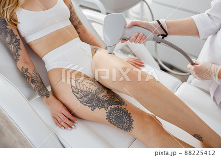 Young woman receiving laser treatment in cosmetology clinic Young woman receiving laser treatment in cosmetology clinic 88225412
