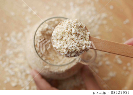 Close up of oats flakes on spoon on table Close up of oats flakes on spoon on table 88225955