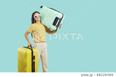 Smiling woman with suitcases ready for summer vacation Smiling woman with suitcases ready for summer vacation 88226489