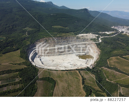 Aerial view industrial of opencast mining quarry with lots of machinery at work - crushed stone and building materials for the constractions industry. Oval mining industrial crater, acid mine drainage Aerial view industrial of opencast mining quarry with lots of machinery at work - crushed stone and building materials for the constractions industry. Oval mining industrial crater, acid mine drainage 88227257