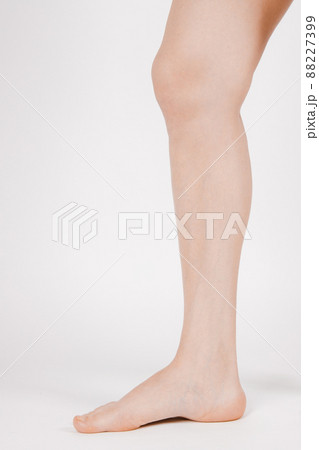 Barefoot and legs isolated on white background. Closeup shot of healthy beautiful female feet. Health and beauty concept. Side view of human foot ream with neutral manicure or pedicure. Sole of foot. 88227399