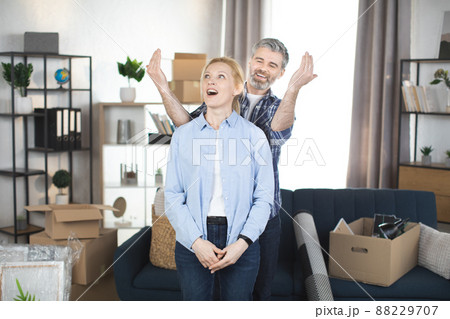 Happy couple man and woman standing in their new cosy appartments after successful real estate deal. 88229707