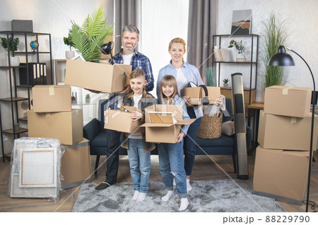 Happy Caucasian family with kids standing with boxes at new apartment Happy Caucasian family with kids standing with boxes at new apartment 88229790