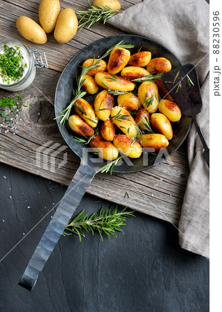 Golden brown fried potatoes with rosemary and herb curd Golden brown fried potatoes with rosemary and herb curd 88230596