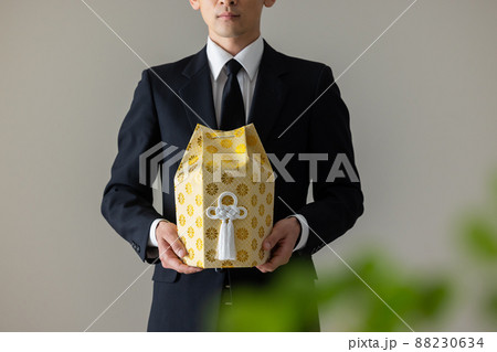 遺骨を抱く喪服の男性 遺骨を抱く喪服の男性 88230634