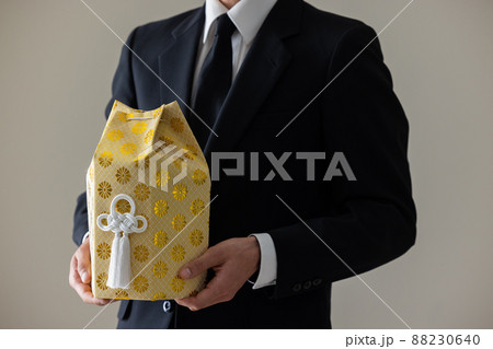 遺骨を抱く喪服の男性  遺骨を抱く喪服の男性  88230640