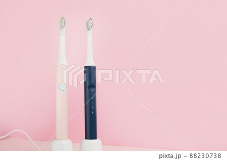 Two new modern ultrasonic toothbrushes. Dental care supplies on pink pastel background. Oral hygiene, dental and gum health, healthy teeth. Dental products Ultrasonic vibration toothbrush. Two new modern ultrasonic toothbrushes. Dental care supplies on pink pastel background. Oral hygiene, dental and gum health, healthy teeth. Dental products Ultrasonic vibration toothbrush. 88230738