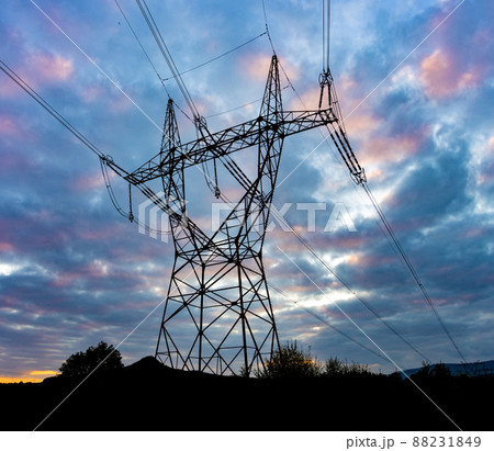 Silhouette of a high voltage tower with the clouds at sunset on a background 88231849