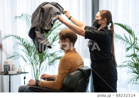 Long-haired hairdresser working with a male client at the beauty slaon 88232514