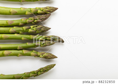 Overhead view of raw green asparagus over white background with copy space Overhead view of raw green asparagus over white background with copy space 88232850