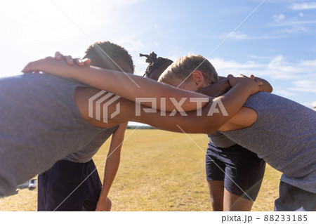 Multiracial elementary schoolboys making huddle during soccer match Multiracial elementary schoolboys making huddle during soccer match 88233185