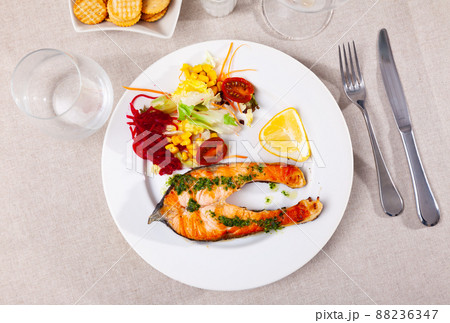 Fried salmon steak with a light vegetable salad 88236347